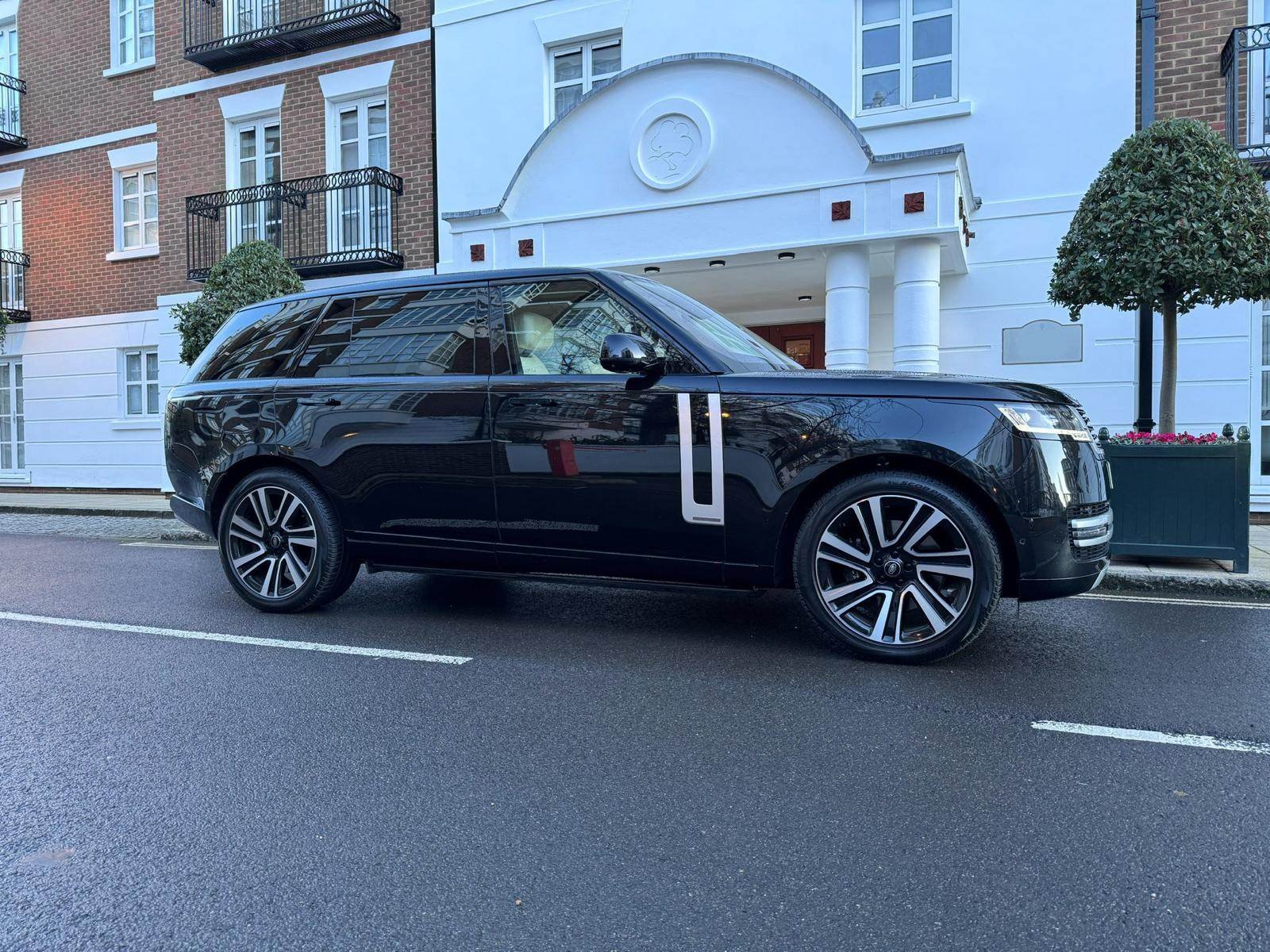 Black Range Rover chauffeur car waiting outside a London residential building for a pre-booked passenger