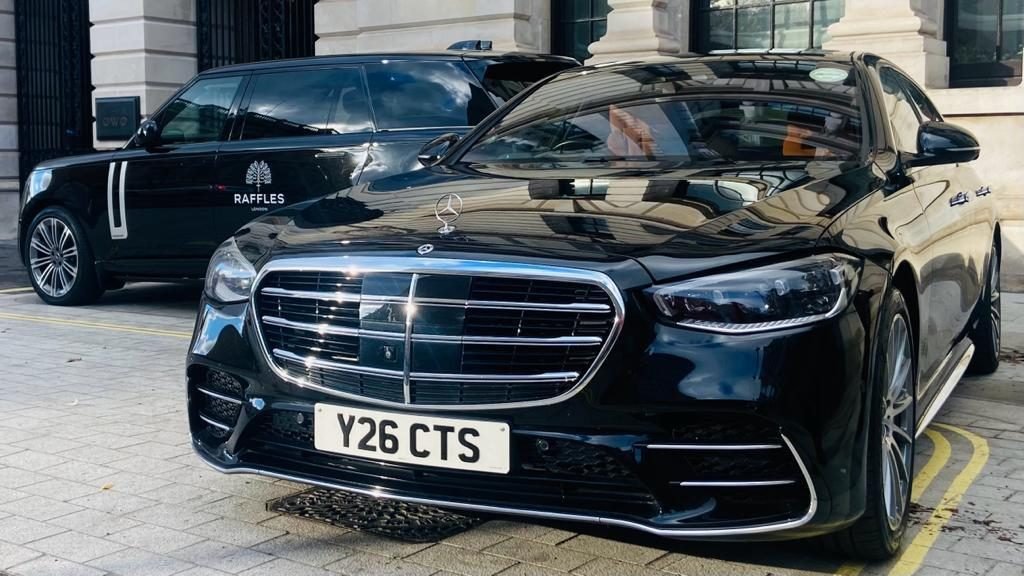 Black Mercedes-Benz S-Class chauffeur car parked outside a London hotel entrance